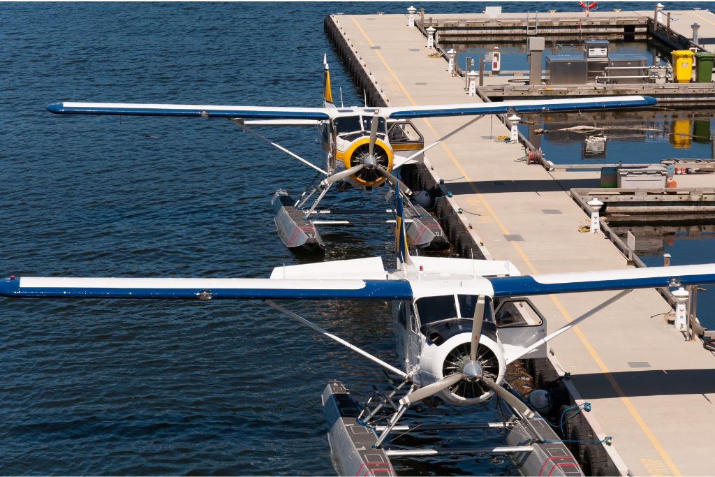 Two Seaplanes parked on the water next to a pier