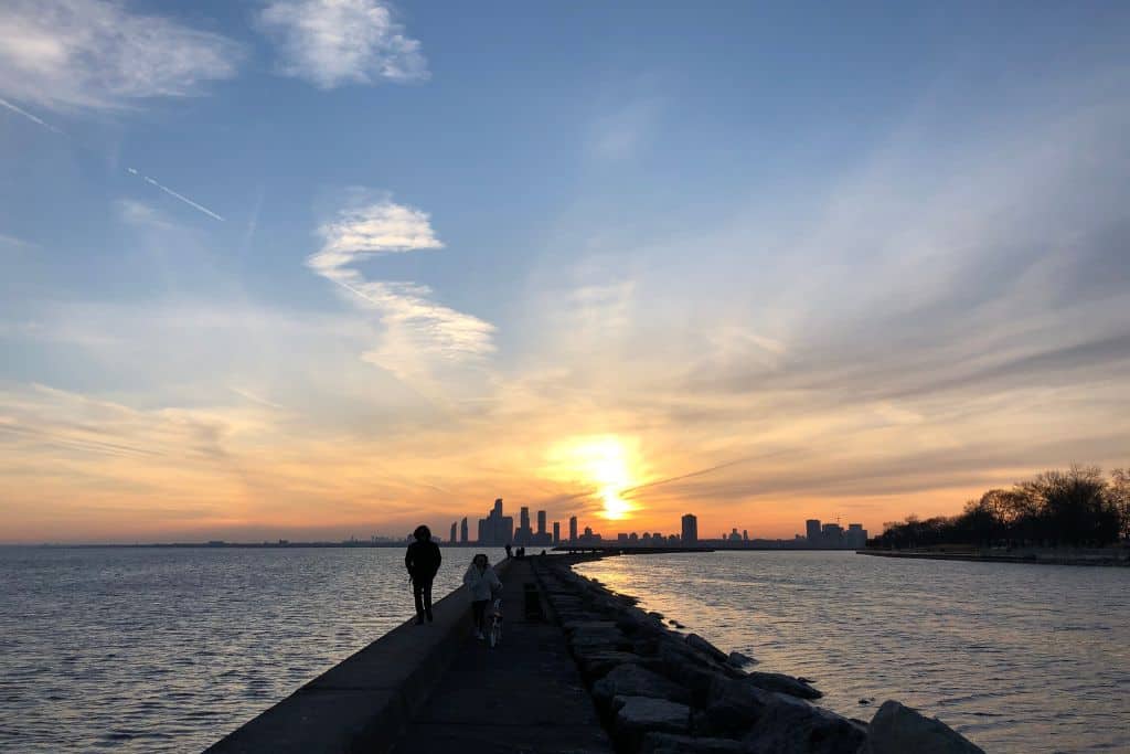 A pathway through the water with the sunset on the horizon, which is one of many sites to see when exploring Toronto on foot