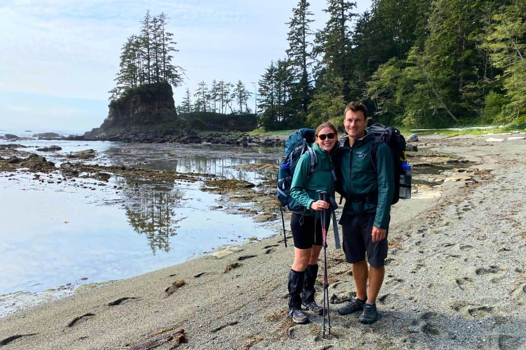 A couple of hikers standing on a rugged beach on the West Coast Trail.