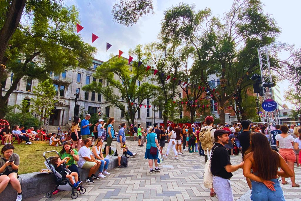 A group of people gathered at a street festival in summer in Montreal, Canada.