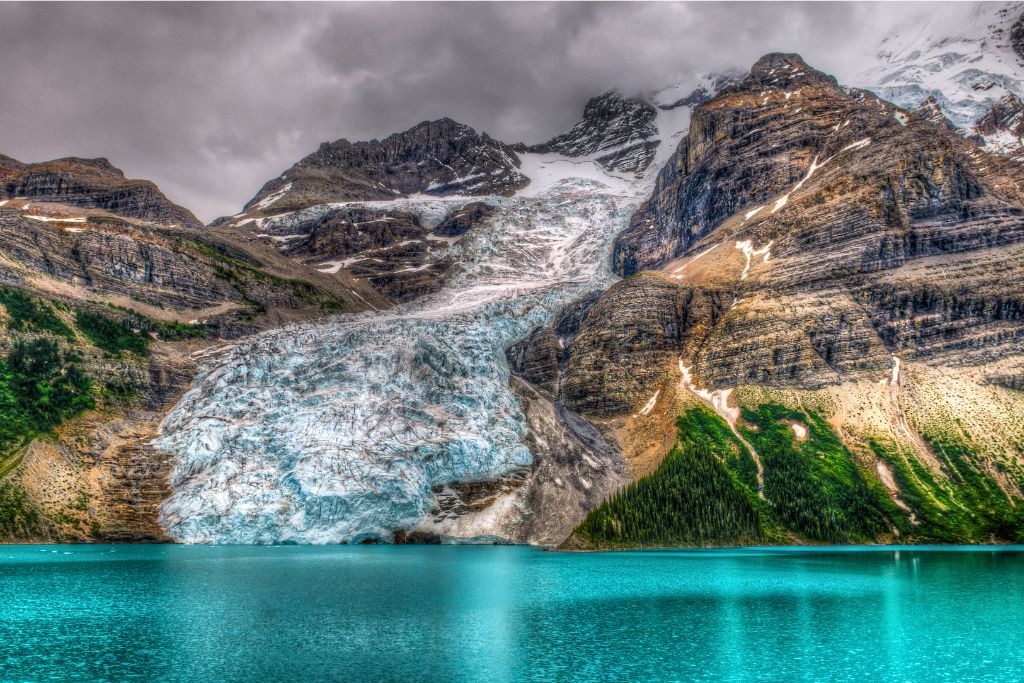 A glacier leading into the turquoise blue water of Berg Lake, which is one of the best places to go backpacking in Canada.
