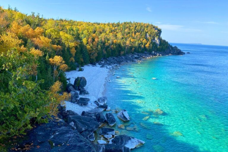 A white pebble beach and turquoise blue water on the Bruce Peninsula during the fall.