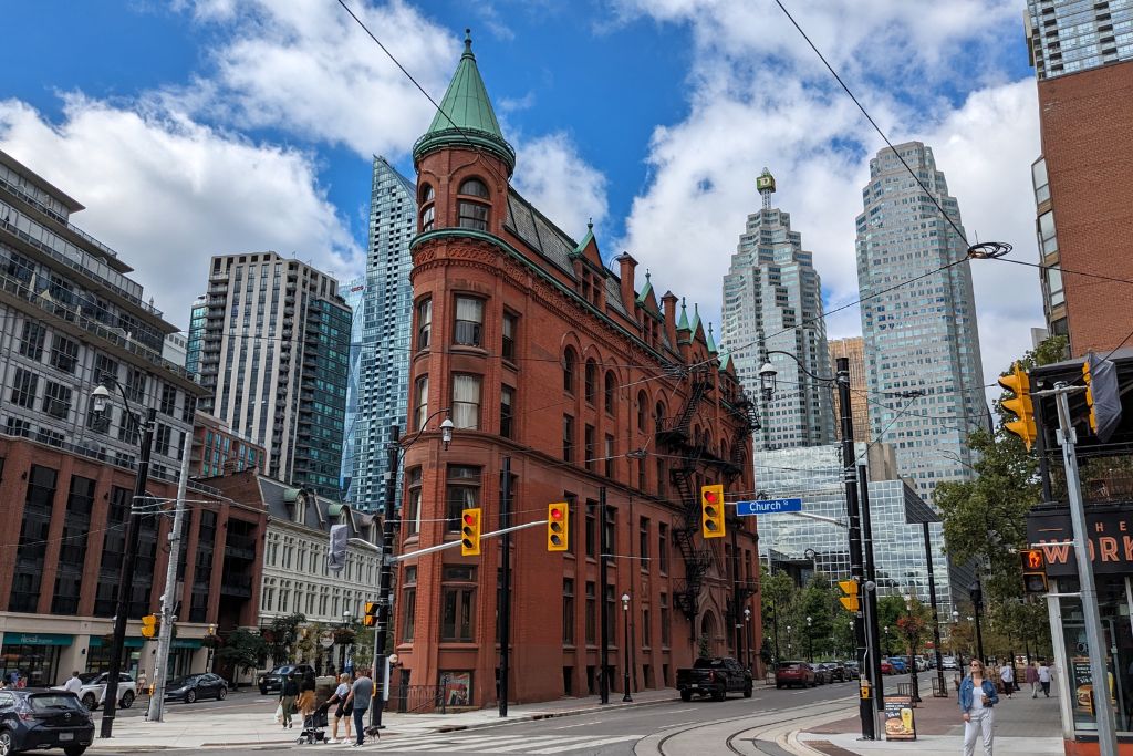 The 'Flatiron' building in Old Toronto, surrounded by modern infrastructure, which is one of the pros and cons of living in Canada.