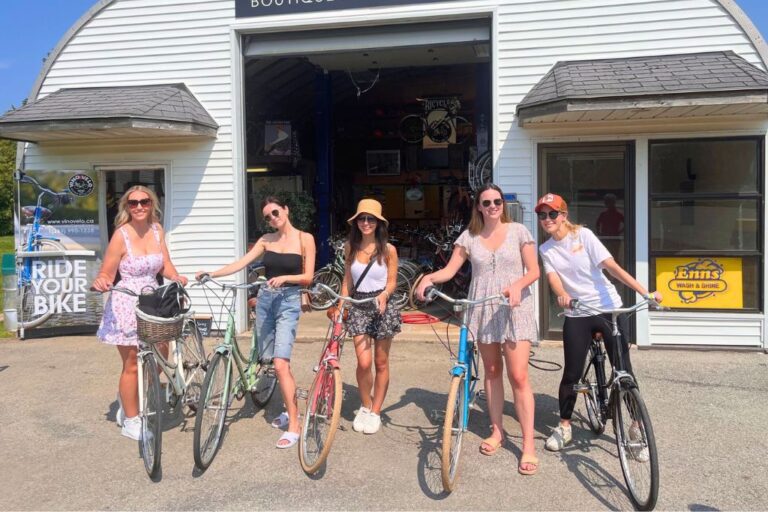 A group of women posing with their bikes, ready to start one of the Niagara bike wine tours.