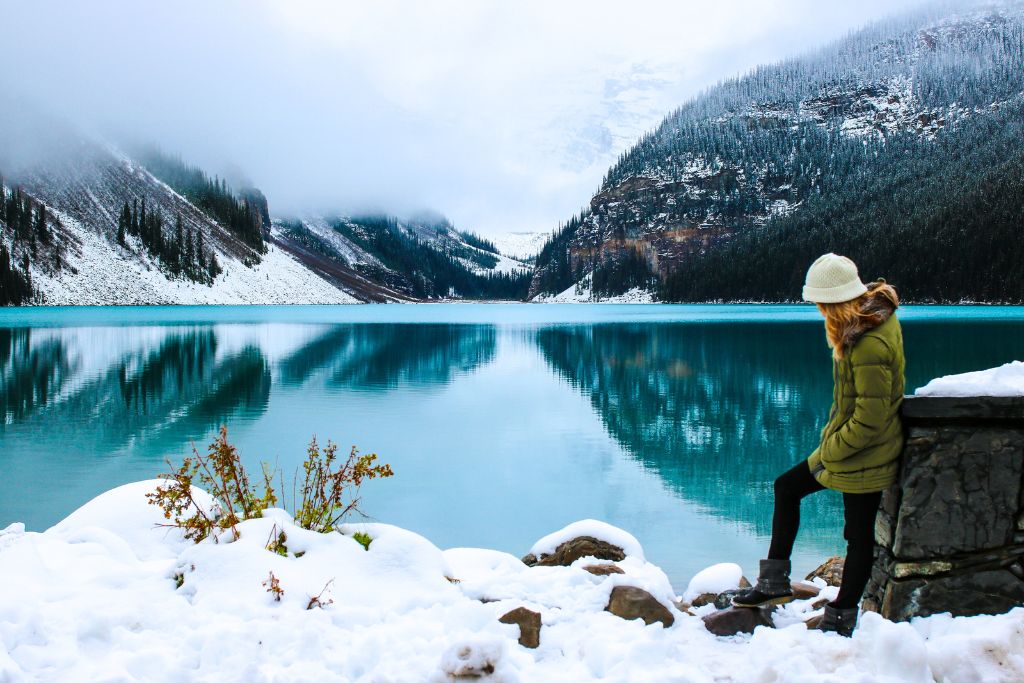 Fun facts about Canada - A woman standing on the snow covered shore of Lake Louise in Alberta.