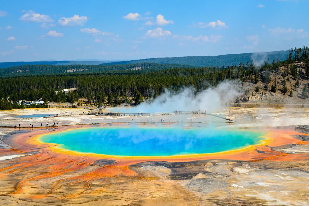 The Grand Prismatic Spring in Yellowstone National Park. The pool's centre is a vibrant blue, surrounded by a fiery yellow and orange ring.