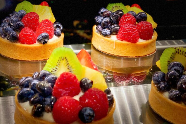 Three small colourful fruit tarts, which are one of the best things to eat in France.